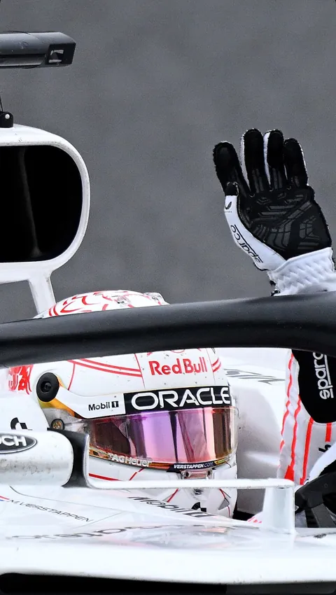 A gloved hand raised from the cockpit of the white car, visor down.