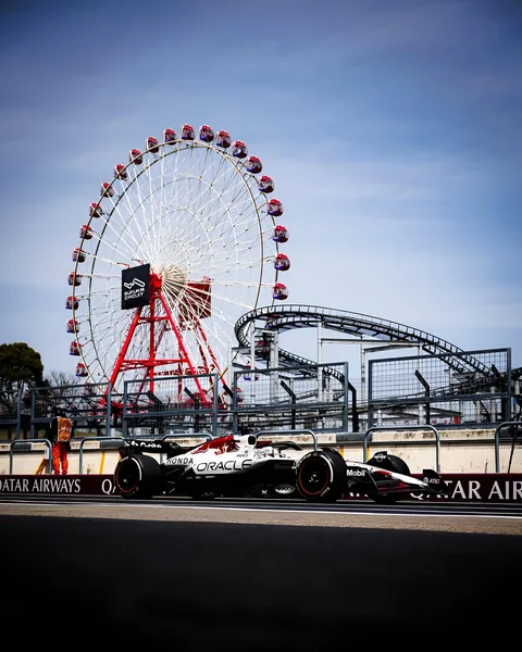 The white RB21 passing the Suzuka ferris wheel, a marshal standing at the barrier.